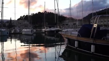 Yachts are moored to the pier against the backdrop of mountains in the evening. High quality 4k footage