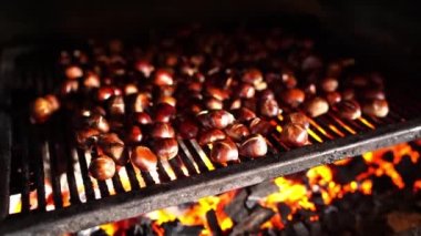 Chestnuts are baked on a grill on coals in the oven. High quality 4k footage