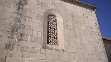 Patterned lattice on the arched window of the Church of St. Nicholas in Perast. Montenegro. High quality FullHD footage