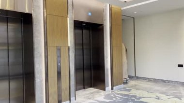 Lobide yerde halı olan modern bir otel asansörü. Yüksek kalite 4k görüntü