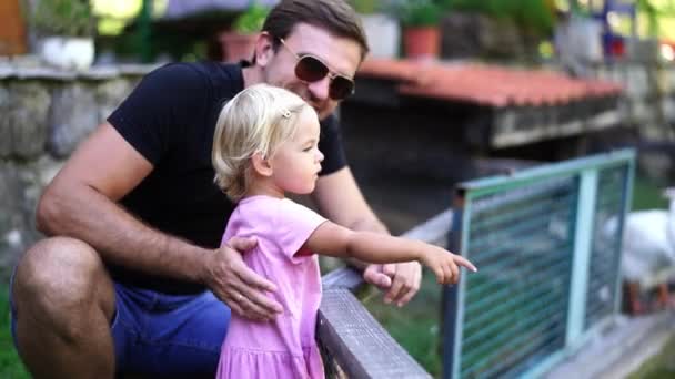 Μπαμπάς Κάθεται Κοντά Στο Φράχτη Δίπλα Ένα Όρθιο Κοριτσάκι Και — Αρχείο Βίντεο