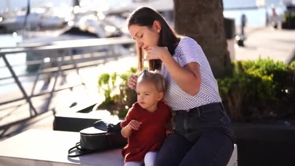 Mom Combs Little Girl Sitting Bench Pier High Quality Footage — Stockvideo