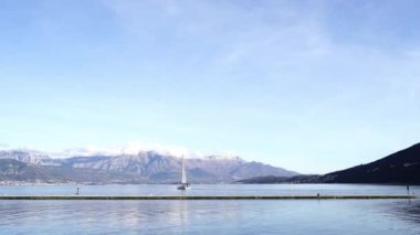 Sailing yacht floats near the pier against the backdrop of a mountain range. High quality 4k footage