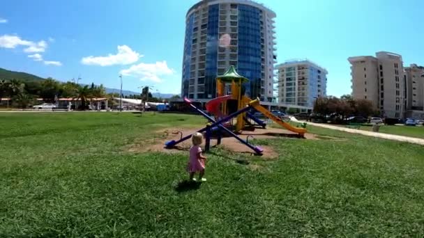 Küçük Kız Salıncakların Yanından Geçiyor Çocuk Parkında Kayıyor Yüksek Kaliteli — Stok video