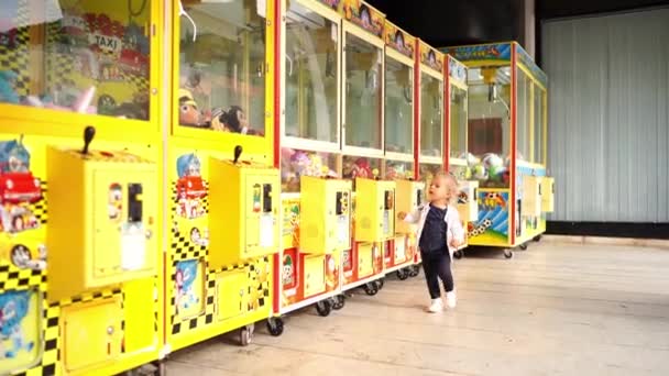 Küçük Kız Içinde Oyuncaklarla Otomatların Yanında Yürüyor Kapı Kollarını Çekiyor — Stok video