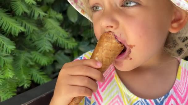 Little Girl Nibbles Ice Cream Cone While Sitting Bench Green — Stockvideo