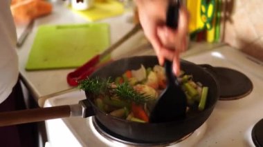 Kadın fırındaki tavada spatulayla sebze pişiriyor. Yüksek kalite 4k görüntü