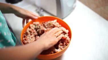 Housewife stirs minced meat in a bowl with her hands. High quality 4k footage