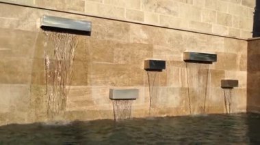 Modern fountain in the form of rectangular panels on a stone wall. High quality 4k footage