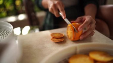 Housewife cuts ripe persimmon into pieces on the table. High quality 4k footage