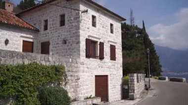 Old white stone house with brown shutters on the windows and a red tiled roof. High quality FullHD footage