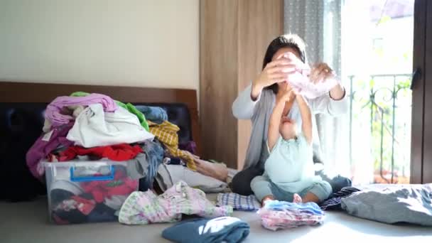 Μαμά Και Κοριτσάκι Διπλώνουν Πολύχρωμα Καθαρά Σεντόνια Ενώ Κάθονται Στο — Αρχείο Βίντεο