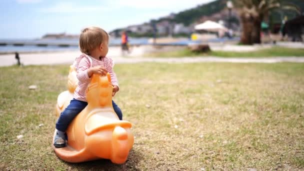 Menina Senta Num Baloiço Parque Infantil Olha Para Trás Imagens — Vídeo de Stock