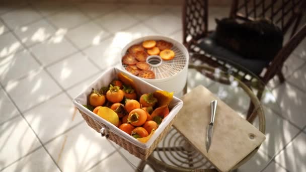 Secador Frutas Com Pedaços Cáqui Fica Uma Mesa Lado Cesto — Vídeo de Stock