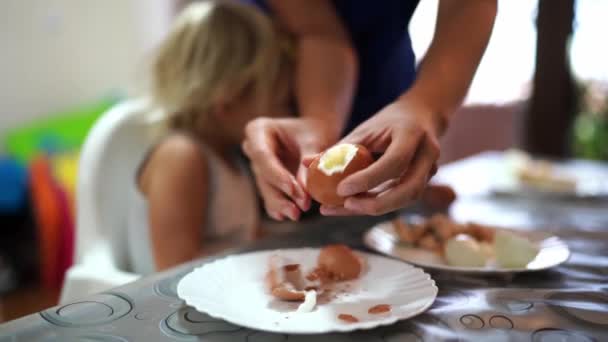 Маленькая Девочка Смотрит Мать Очищает Скорлупу Варёного Яйца Высококачественные Кадры — стоковое видео