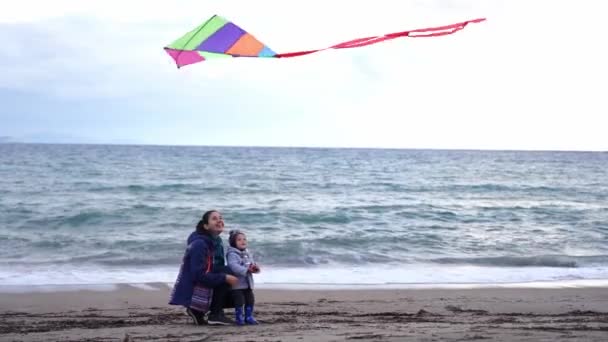 Mom Squats Her Little Daughter Beach Watches Kite Fly High — Vídeos de Stock