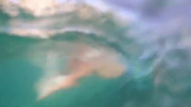 Man swims a butterfly in the sea against the backdrop of mountains. High quality 4k footage