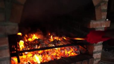 Cook turns the pieces of grilled lamb in a brick oven with tongs. High quality 4k footage