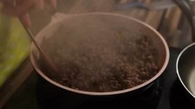 Man mixes minced meat with rosemary in a sauce in a frying pan. High quality 4k footage