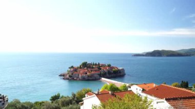 Sveti Stefan adası, mavi deniz ve dağların arka planına karşı. Karadağ. Yüksek kalite 4k görüntü