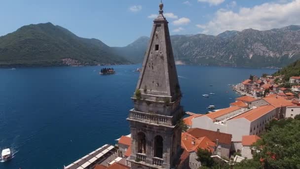 海と山を背景に ペルストの聖ニコラス教会の鐘楼の尖塔 高品質4K映像 — ストック動画