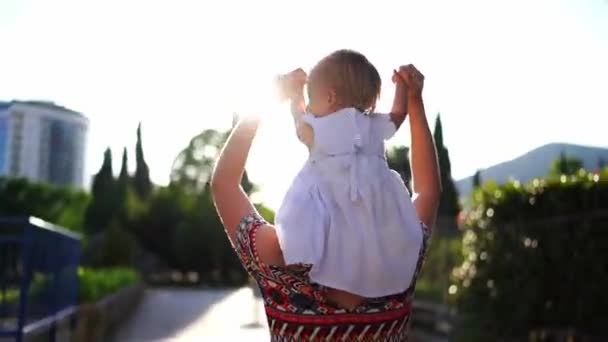 ママは小さな女の子を肩に抱えて手を握っている 高品質のフルHd映像 — ストック動画