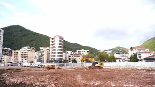 Escavadeira Cava Chão Canteiro Obras Frente Edifícios Altos Imagens Alta — Vídeo de Stock
