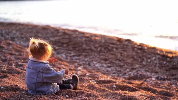 Little Girl Pours Sand Small Pebbles Sitting Beach Sea High — Stock video