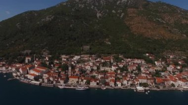 Aerial view of ancient houses next to St. Nicholas church in Perast. High quality 4k footage