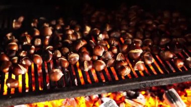 Fresh chestnuts are cooked on a charcoal grill in a brick oven. High quality 4k footage