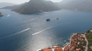 Aerial view of the islands opposite Perast with green mountains in the background. High quality 4k footage