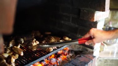 Chef turns the pieces of grilled lamb with tongs. High quality 4k footage