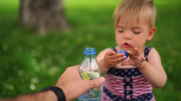 Little Girl Takes Puts Cap Water Bottle Her Father Hand — Vídeos de Stock