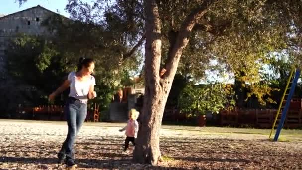 소녀는 놀이터에서 어머니를 쫓아가다가 넘어지고 일어나서 닦는다 고품질 — 비디오