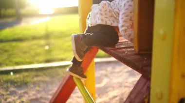 Little girl climbs a ladder up a slide and slides down. High quality 4k footage
