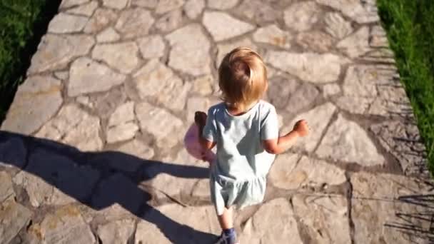 Маленька Дівчинка Біжить Плитковою Стежкою Газоні Панамським Капелюхом Руці Високоякісні — стокове відео