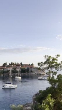 Sailing catamarans are moored near the island of Sveti Stefan. Montenegro. High quality 4k footage