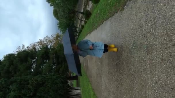 Κοριτσάκι Ομπρέλα Περπατά Κατά Μήκος Ενός Ασφαλτοστρωμένου Μονοπατιού Στο Πάρκο — Αρχείο Βίντεο