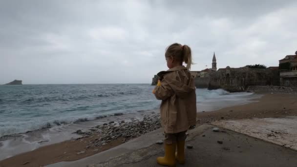 Little Girl Raincoat Rubber Boots Stands Shore Tells Something Her — Stock video
