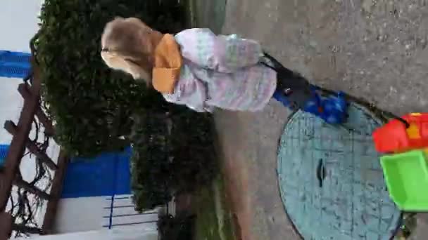 Κοριτσάκι Τρέχει Στην Άσφαλτο Στην Αυλή Ένα Αυτοκινητάκι Στο Σκοινί — Αρχείο Βίντεο