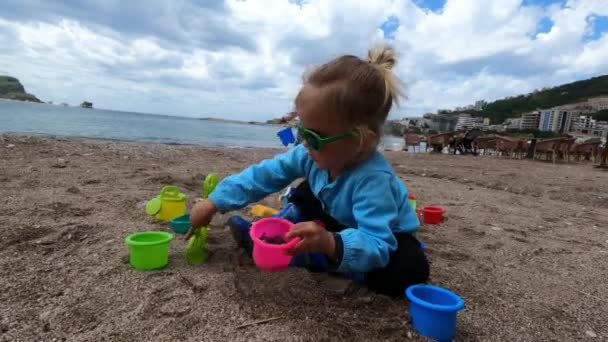 Little Girl Sits Beach Pours Sand Rake Bucket High Quality — Video Stock