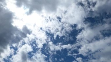 Sun peeks through the white clouds in the blue sky. High quality 4k footage