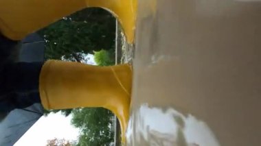 Little girl jumps through the puddles on the path. Close-up. High quality 4k footage