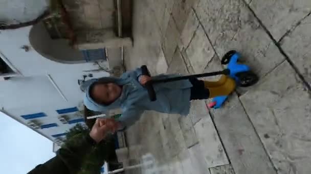 Маленька Дівчинка Їде Скутері Тримаючи Татову Руку Під Дощем Вниз — стокове відео