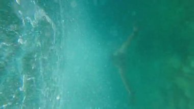 Young smiling swimmer in goggles swims underwater. High quality 4k footage