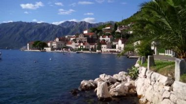 Boat sways on the waves off the coast of Perast against the background of the mountains. Montenegro. High quality FullHD footage