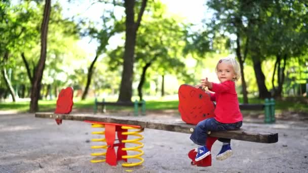 Little Girl Sits Half Turned Spring Swing Park High Quality — Wideo stockowe