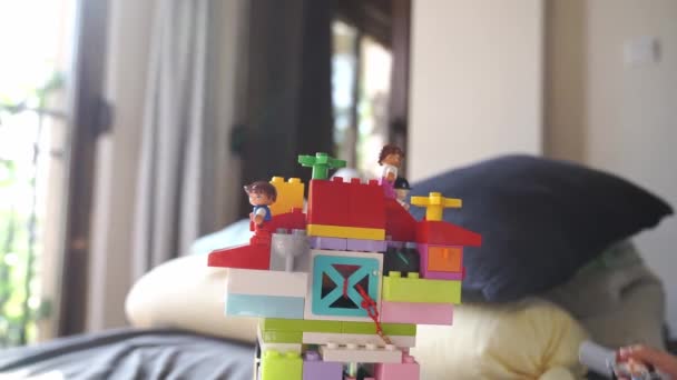 小さな女の子が部屋のベッドの上でレゴで遊ぶ 高品質のフルHd映像 — ストック動画