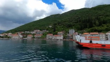 Cars pull off the ferry ashore at the foot of the mountains. High quality 4k footage