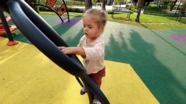 Little girl climbing the arched monkey bars. High quality 4k footage